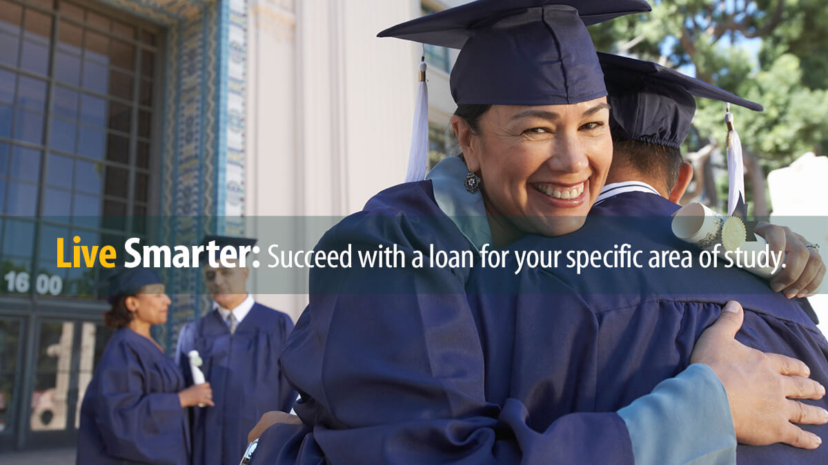 Graduate college students in caps and gowns congratulate each other after graduation ceremony